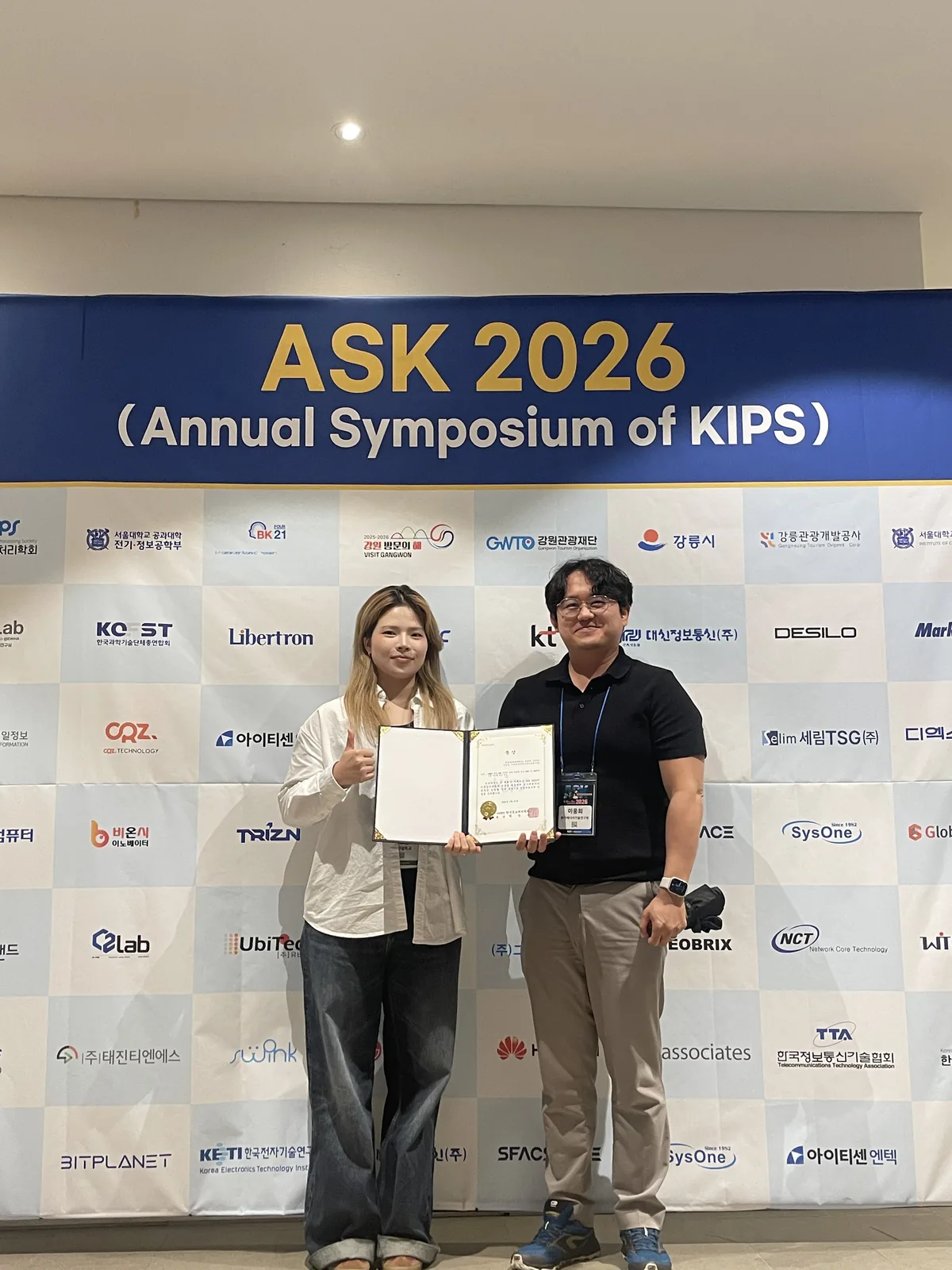 ASK 2026 학회장에서 동상 수여 후 기념 촬영 — 최효은 학생과 이웅희 PI